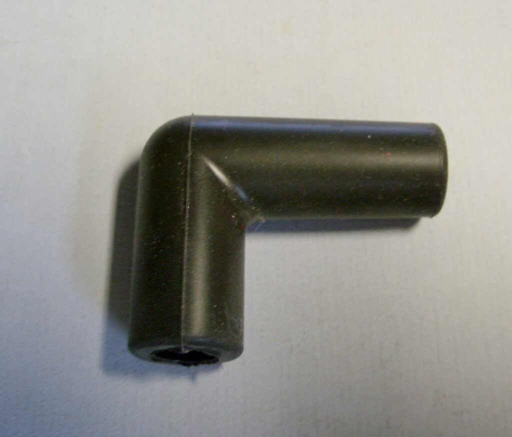 A black plastic Right angle spark plug wire boot on a white surface.