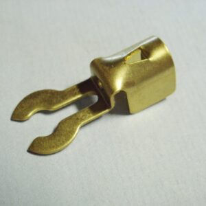 An image of a brass forked crimp terminal with spike on a white surface.