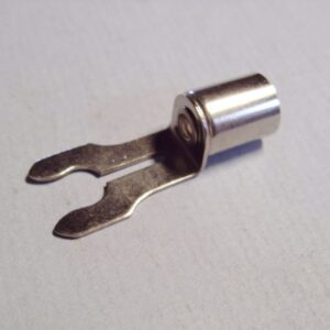 A nickel plated brass forked solder type spark plug terminal on a white surface.