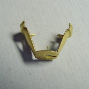 A straight brass distributor cap/coil terminal plated clip on a white surface.