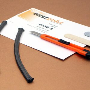 A pair of scissors and a piece of paper on a table.