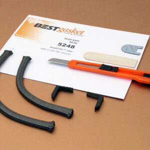 A pair of AMC Cast iron head 6 cyl. 196 OHV head gaskets and a piece of paper on a table.